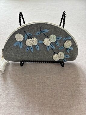 Grey embroidered floral half moon clutch.